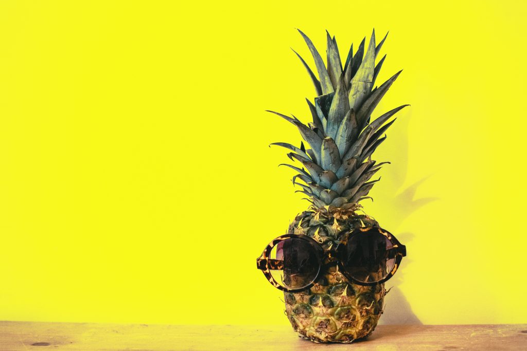 Green pineapple fruit with brown framed sunglasses beside 1161547